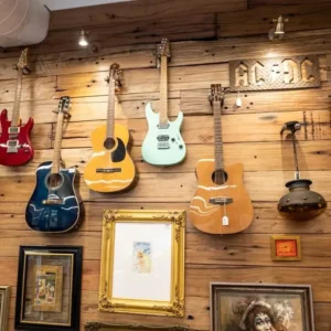 A wall of second-hand acoustic and electric guitars.