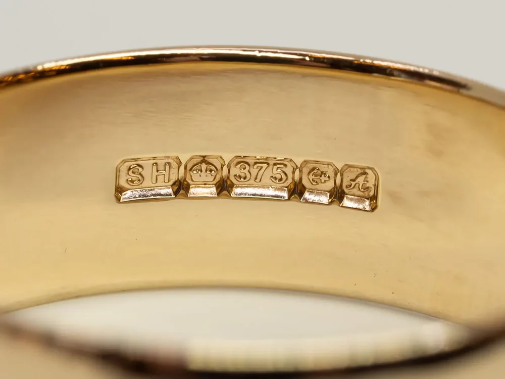 A ring with a number of different stamps known as hallmarks, which shows a rings gold content.