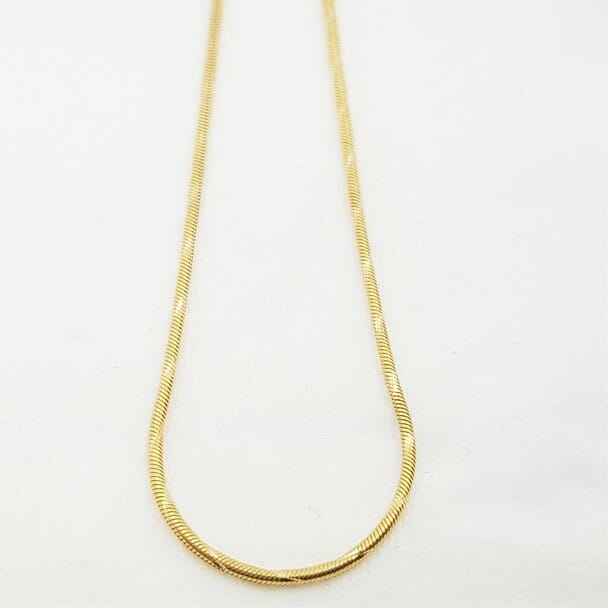 This gold necklace displays the snake link design. The links are tightly woven and reminiscent of a snakes skin.